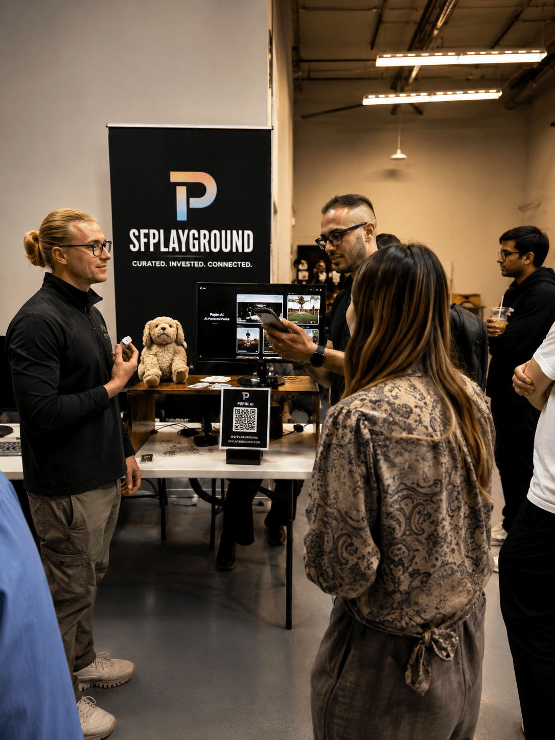 Founders demoing at a Pitch Playoffs booth with SFPLAYGROUND branding
